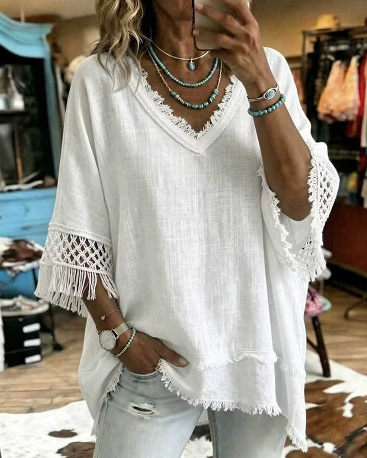 Lifestyle shot of a woman wearing the white Kaelani blouse, styled casually for a relaxed outdoor setting.
