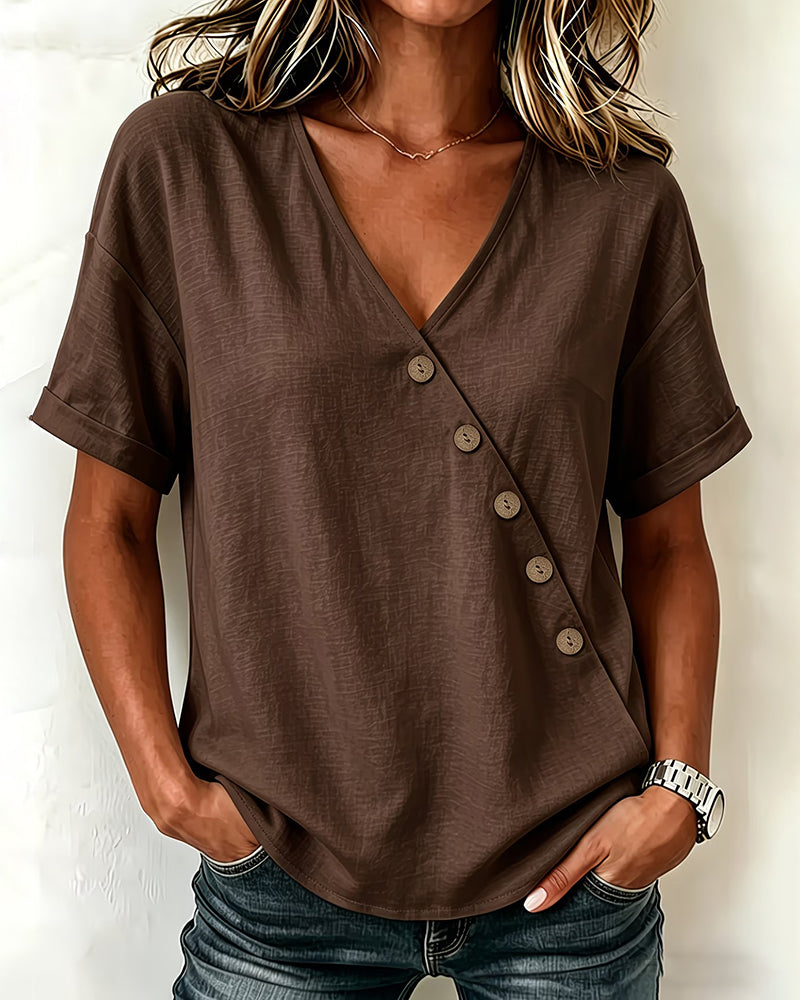 Close-up of the unique asymmetrical button detail and v-neckline on the navy blue blouse.