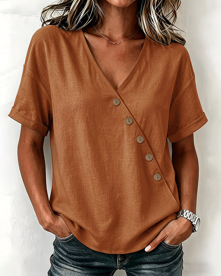 Flat lay of the dark gray asymmetrical button blouse, displaying its solid color and design elements.