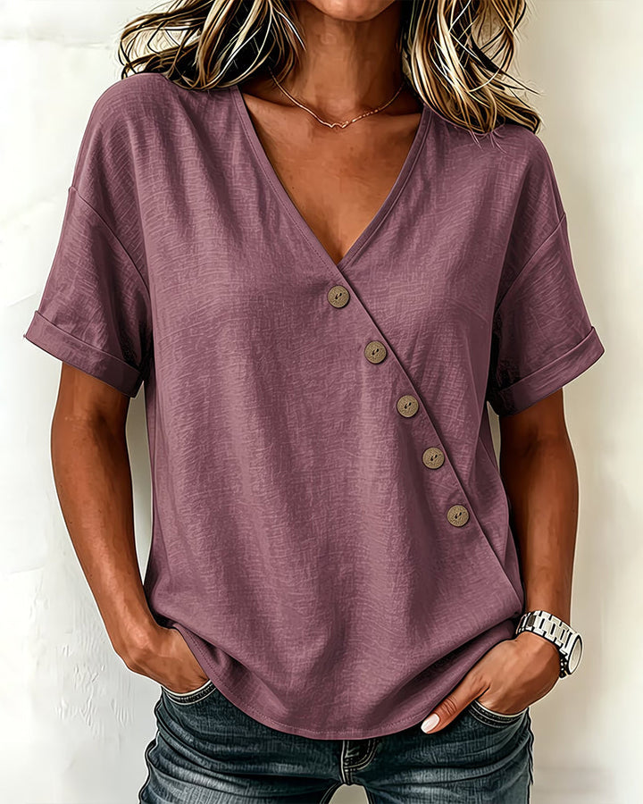 Woman smiling, wearing the khaki asymmetrical button blouse, perfect for a relaxed weekend look.