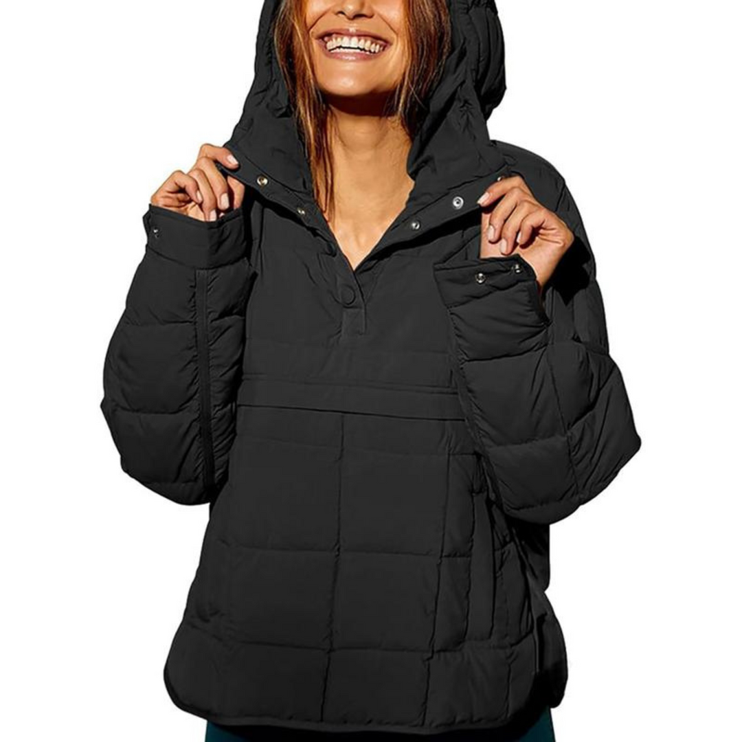 Back view of a woman in the light brown oversized hooded pullover jacket, highlighting its ample coverage.