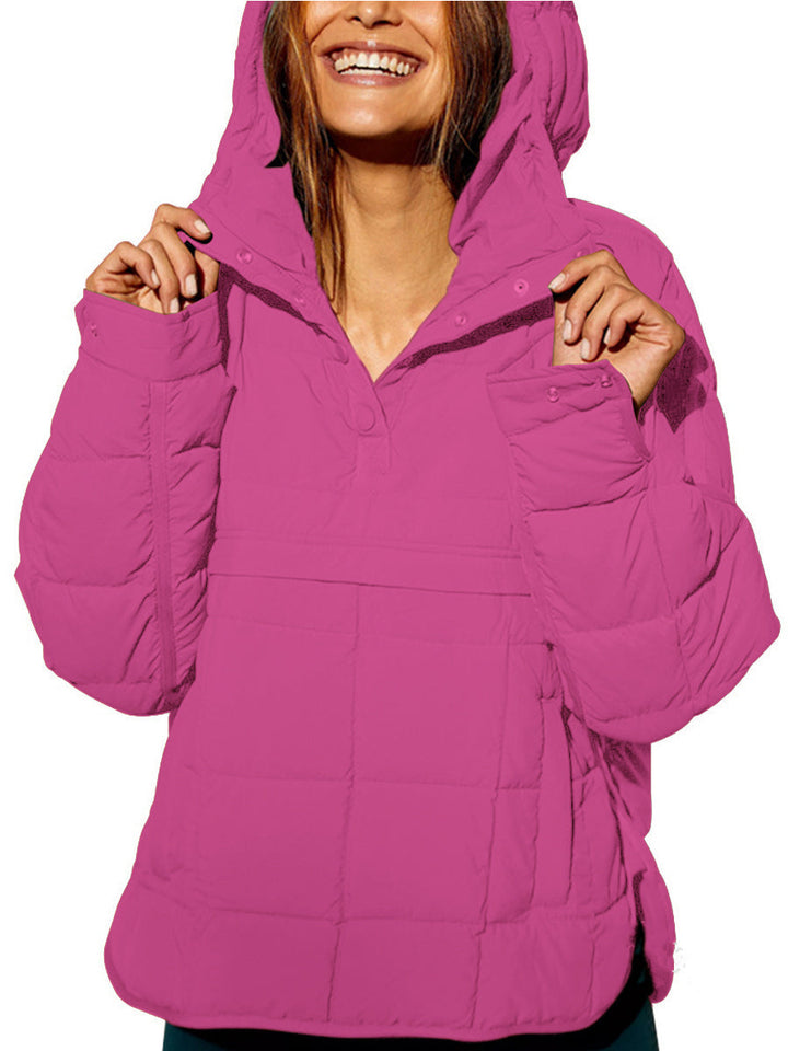 Lifestyle shot of a woman comfortably lounging in the purple oversized hooded pullover jacket at home.