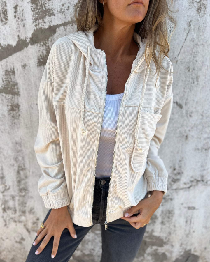 Front view of a woman wearing a light beige Anya relaxed corduroy jacket, showcasing its comfortable fit.