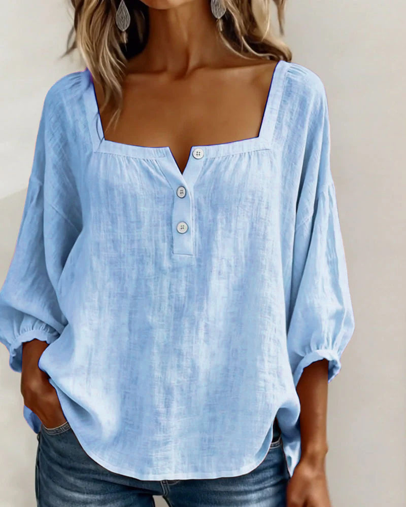 Anya blouse in gray, paired with light wash denim for a casual look.