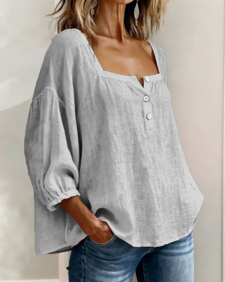 Close-up on the small, delicate buttons adorning the white Anya blouse.