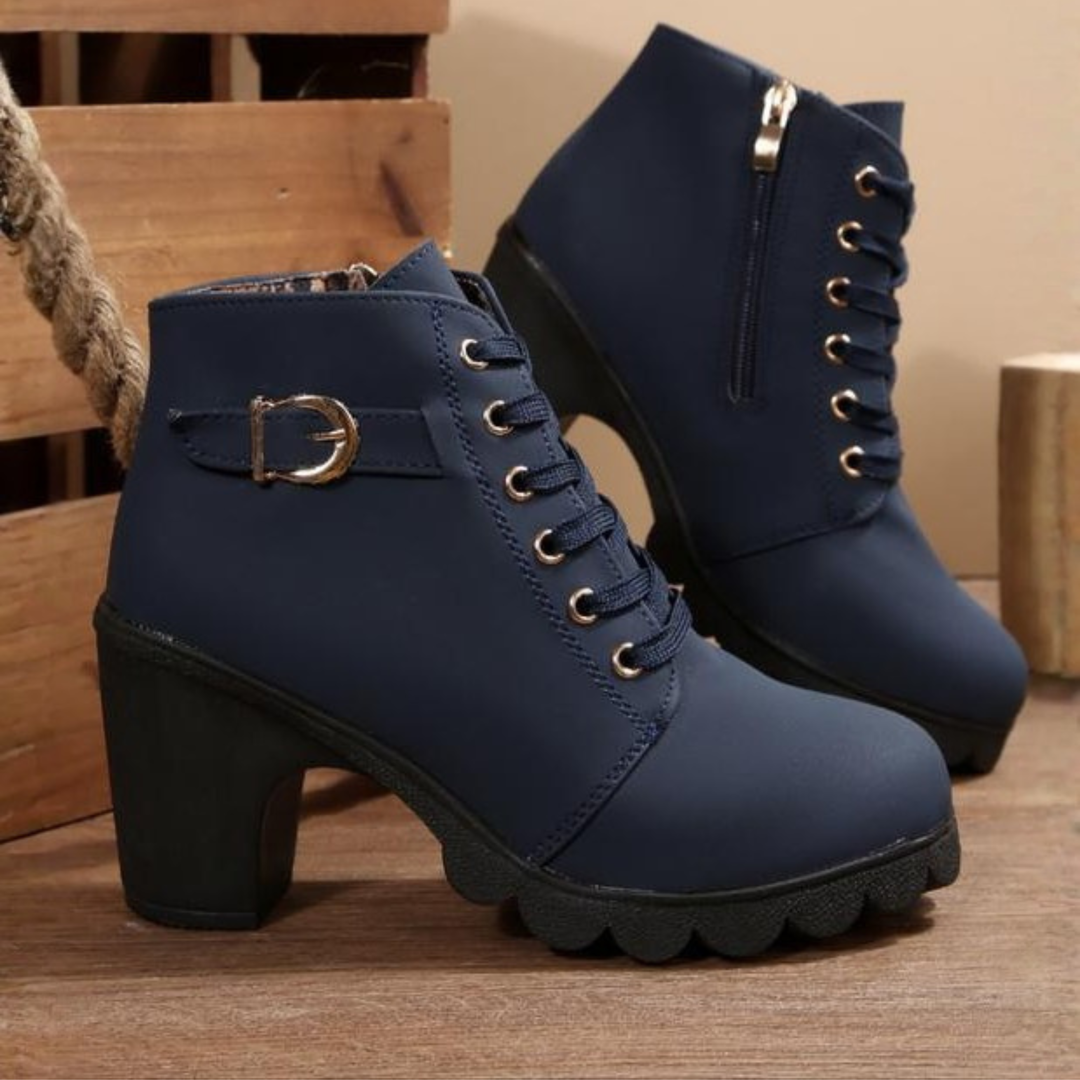 Lifestyle image of a person standing, wearing black chunky ankle boots paired with jeans, demonstrating their versatile appeal.