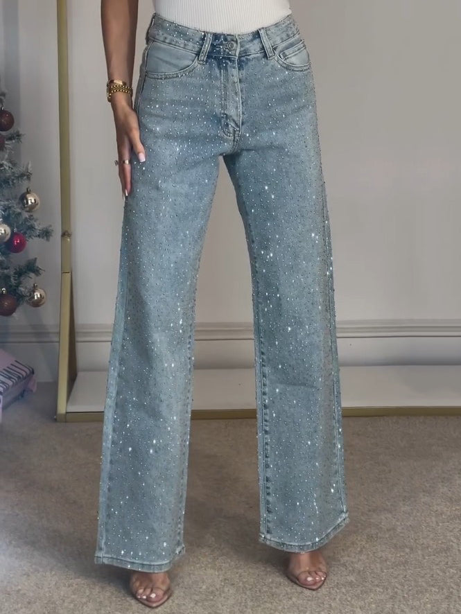 Close-up detail of the diamanté embellishments on the black cotton denim of the straight leg jeans.