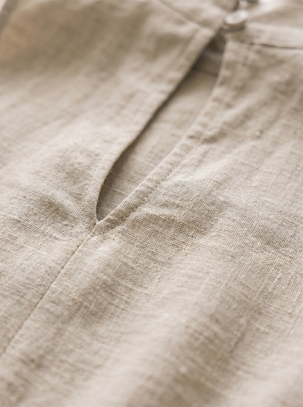Overhead view of the light pink jumpsuit laid flat, showing the full design and fabric composition.