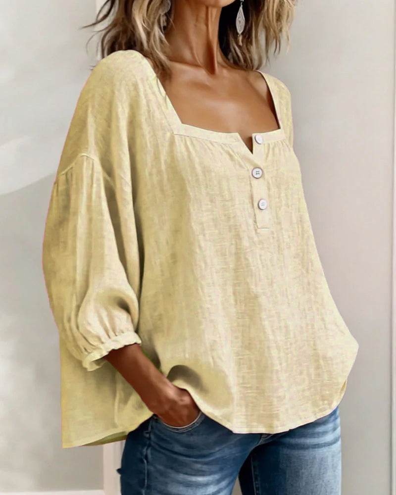 Close-up of the stitching and craftsmanship on a white square neck blouse.