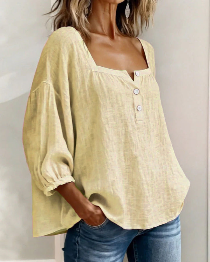 Close-up of the stitching and craftsmanship on a white square neck blouse.