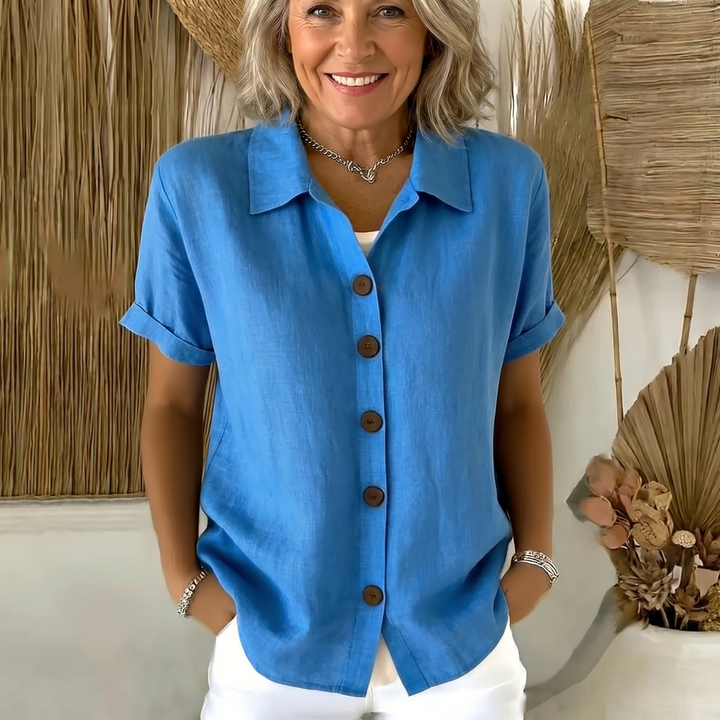 Close-up detail of the classic collar and button closure on the white button-front shirt, highlighting the quality stitching.