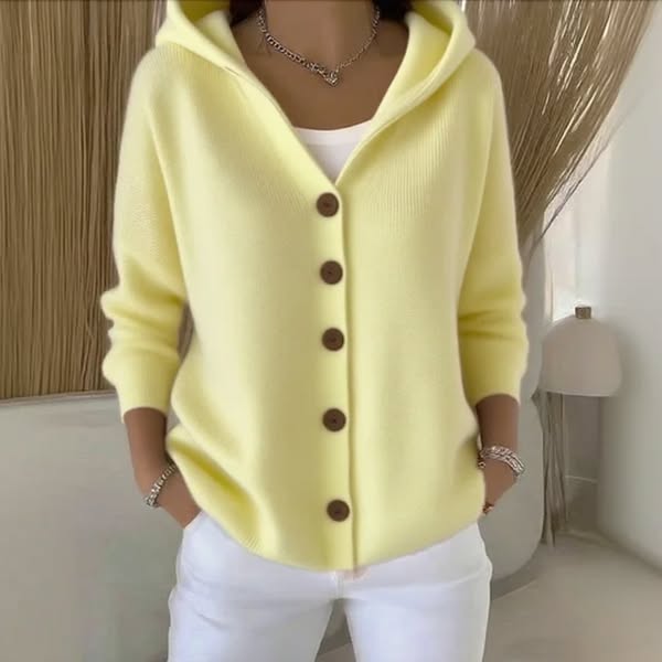 Lifestyle shot of a woman wearing the Elara soft hooded knit cardigan in a blush rose, casually styled for a relaxed day out.