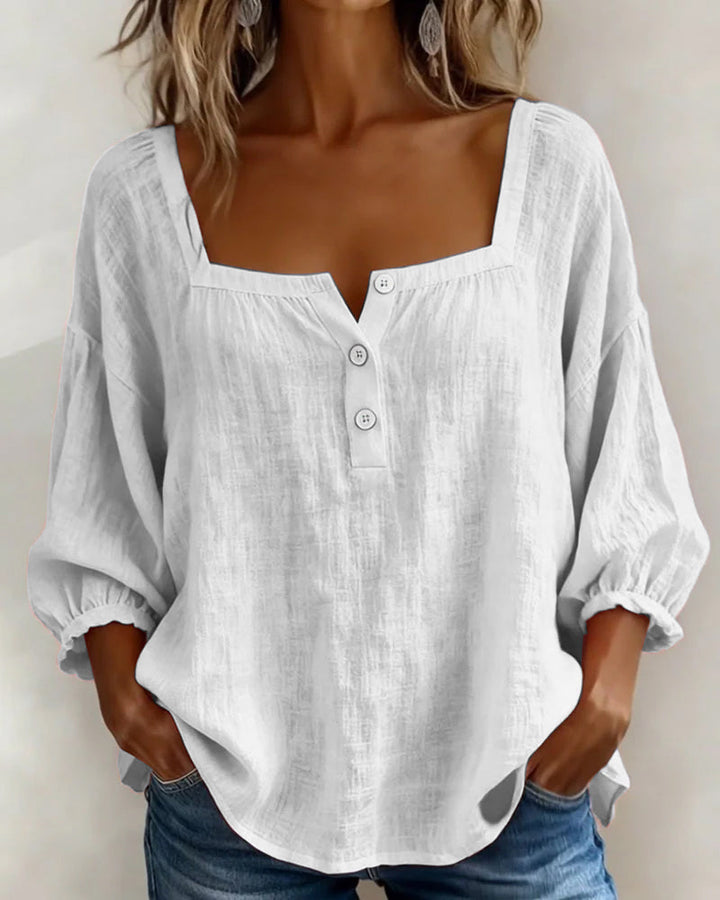 Detail shot of the cotton and linen fabric on a gray square neck blouse, showing its breathability.