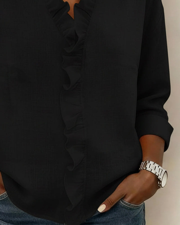Overhead shot of the blue ruffled V-neck blouse laid flat, displaying its full design.