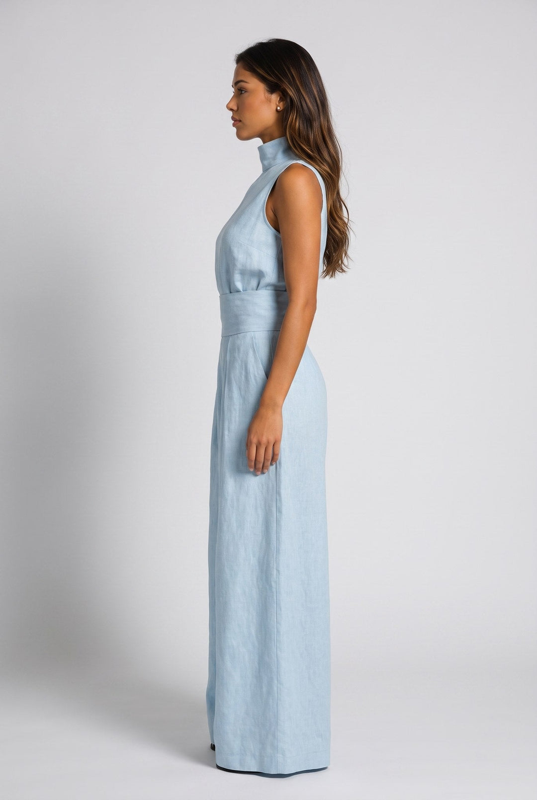 Close-up of the high neck and sleeveless cut on the peach jumpsuit, detailing the fabric's soft drape.