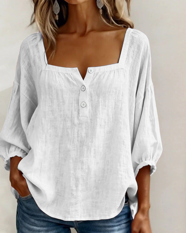 Detail shot of the cotton and linen fabric blend on a pink square neck blouse, emphasizing its breathability.