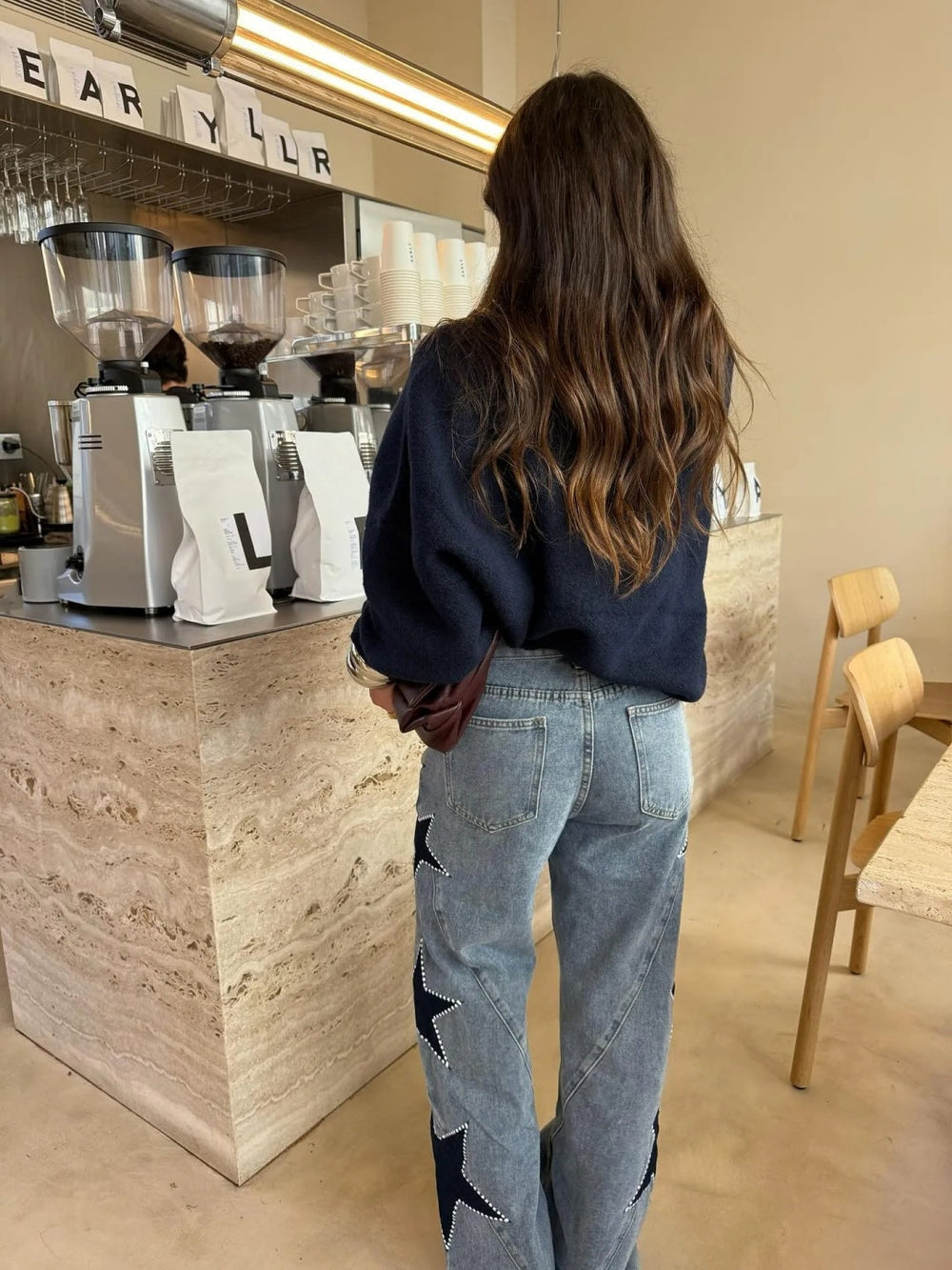 Side profile of model showcasing the star print detailing on the leg of the Evadne jeans.