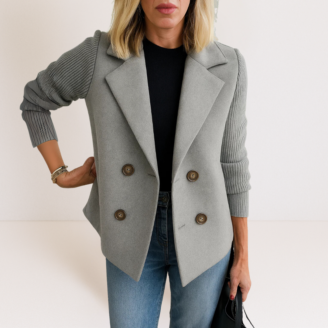 Side profile of a woman wearing the grey Evadne knit sleeve blazer, highlighting the structured shoulders and sleeve texture.