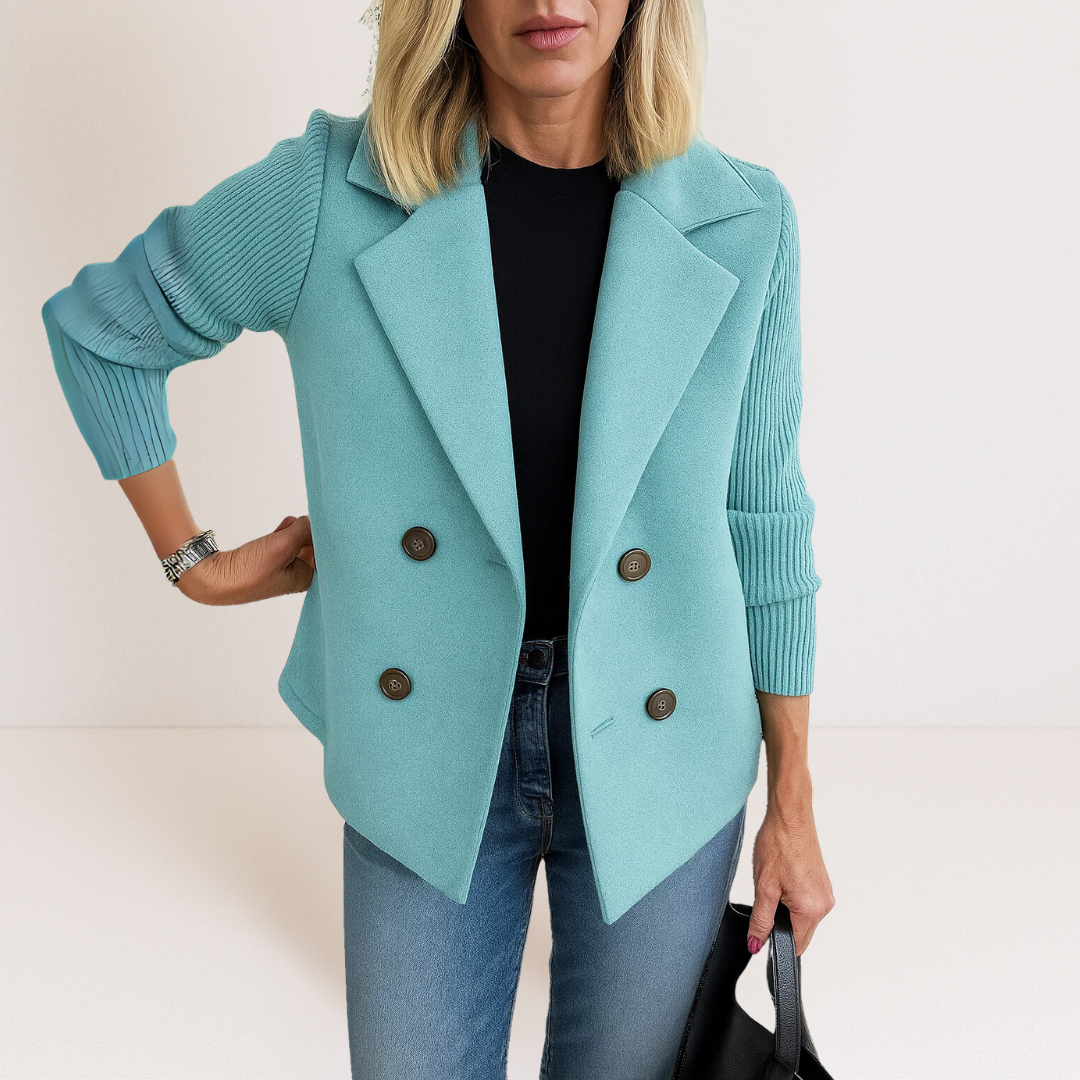 A model smiling while wearing the pink Evadne knit sleeve blazer in a relaxed, bright outdoor setting, emphasizing comfort.
