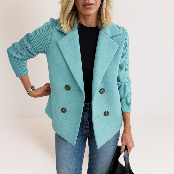 A model smiling while wearing the pink Evadne knit sleeve blazer in a relaxed, bright outdoor setting, emphasizing comfort.
