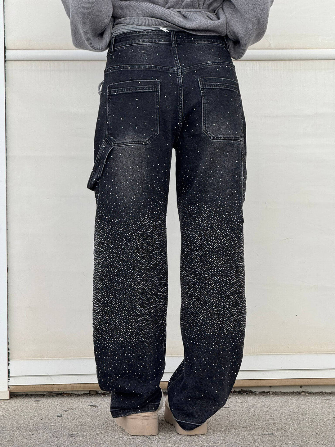 Close-up of the jewel embellishments on the black carpenter jeans, showing their sparkle.