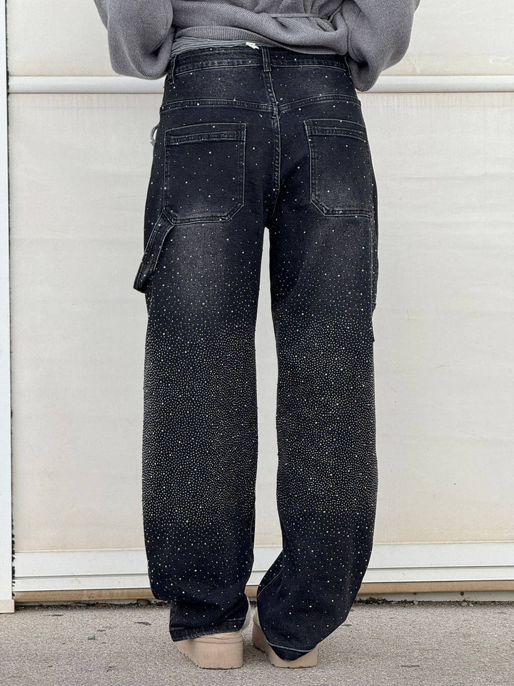 Close-up of the jewel embellishments on the black carpenter jeans, showing their sparkle.