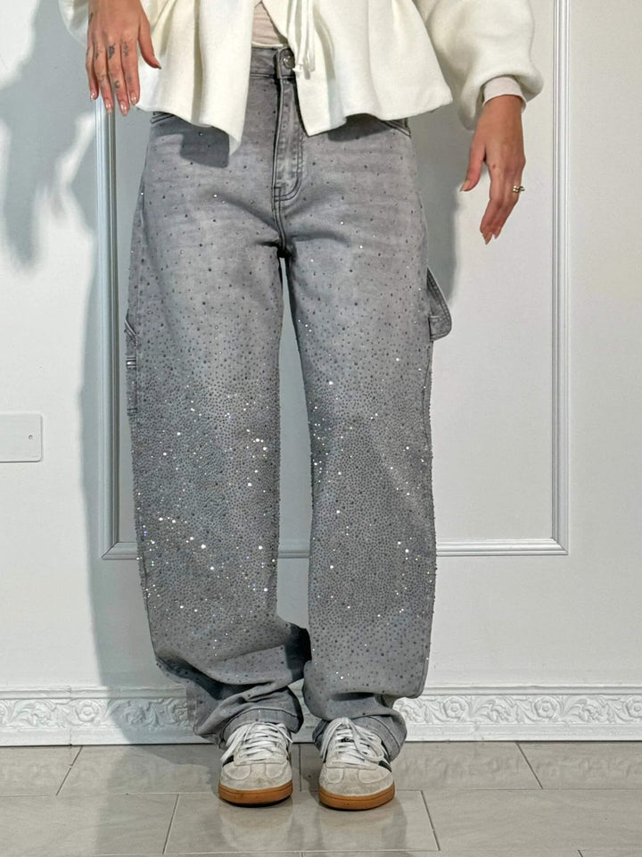 Detailed image of the hemline and embellishments on the black carpenter jeans.