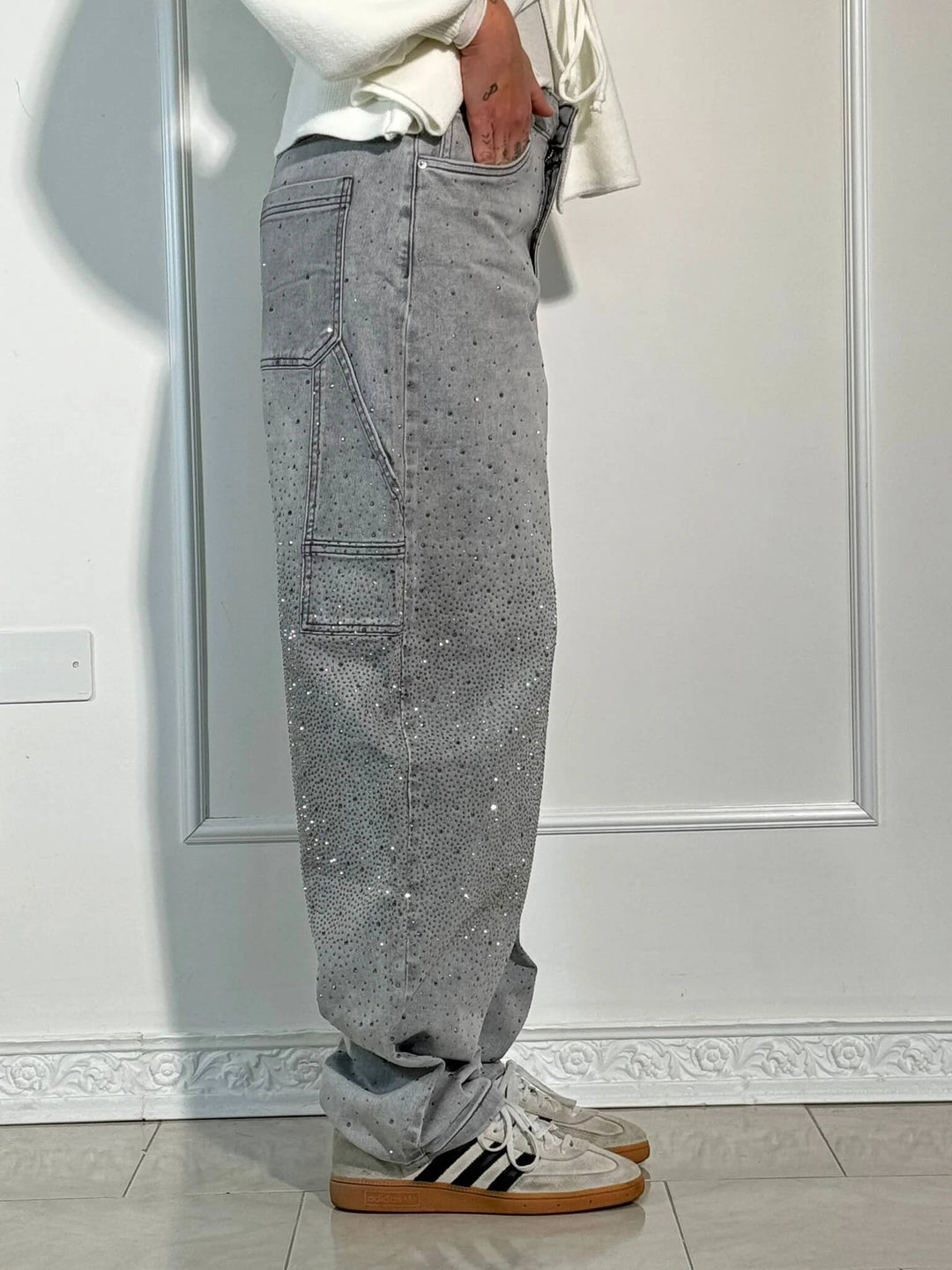 Texture and weave of the black 100% cotton material on the embellished jeans.