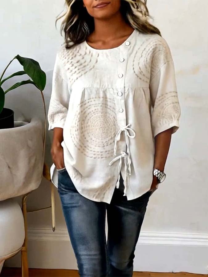 Model wearing the Isolde artisan embroidered top with dark denim, demonstrating the adjustable side tie and overall elegant drape.