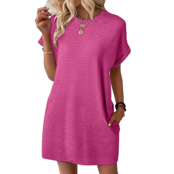 Front view of a woman wearing a light-colored Kira casual summer dress, styled for a relaxed outdoor setting.