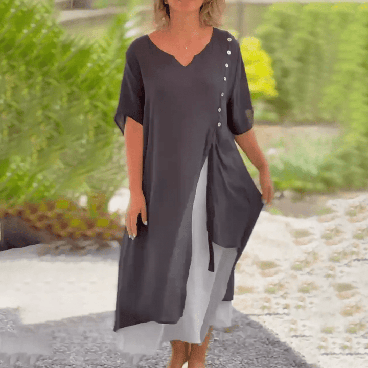 Woman walking in a black Liana classic maxi dress, illustrating its fluid silhouette.