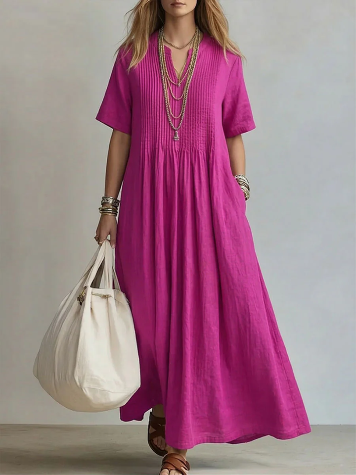 Front view of a woman wearing the blush pink pleated maxi dress, showcasing the elegant flow of the fabric.