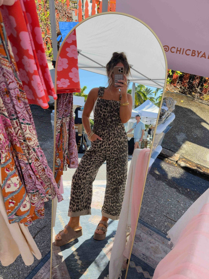 Close-up detail of the metal hardware and side pocket on the stylish leopard print overalls.