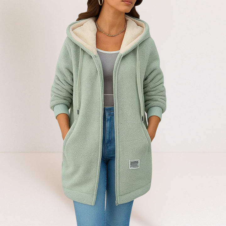 Side profile of a woman wearing a green hooded fleece jacket, highlighting the comfortable fit and long sleeves.