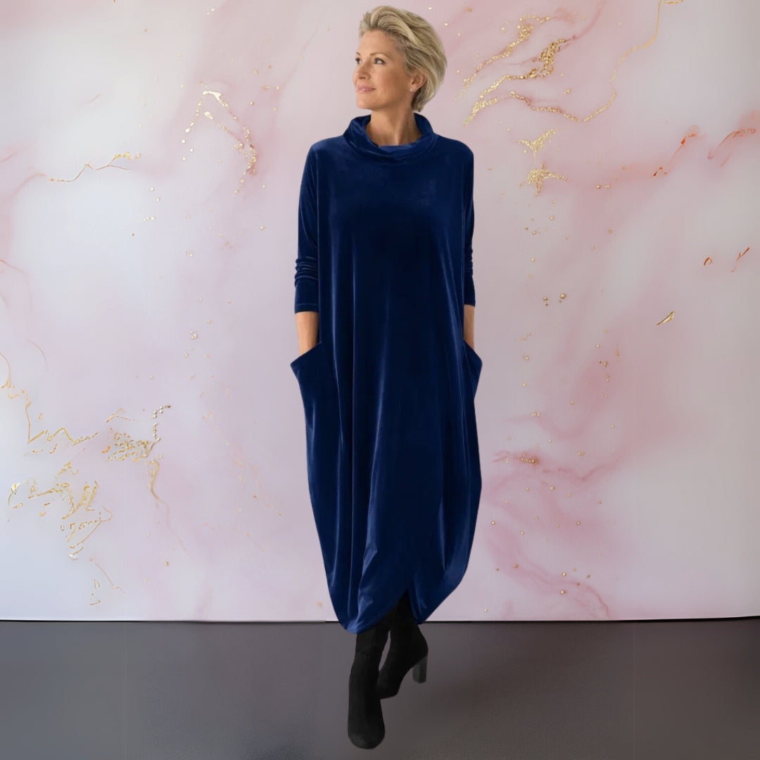 The Rosalind velvet maxi dress in purple, hanging to show its full silhouette and material.
