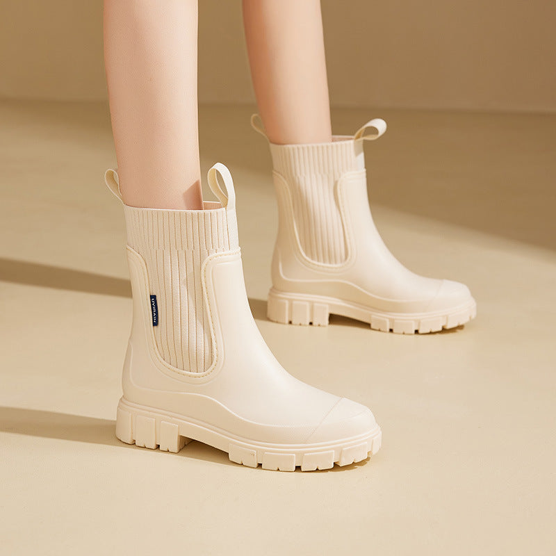Close-up of a black waterproof ankle boot, showcasing the smooth texture and subtle stitching on the side.