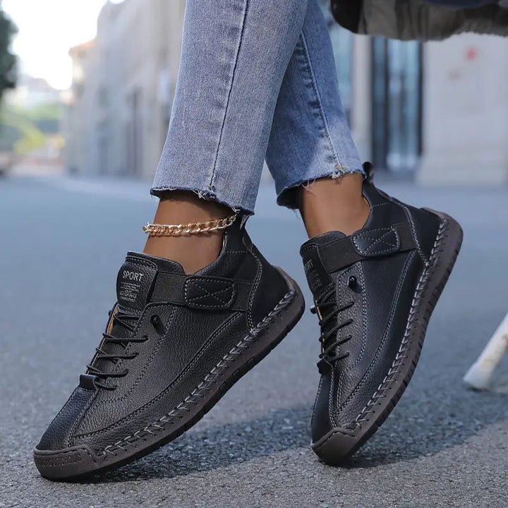 Front angled view of women's black orthopedic comfort sneakers, showcasing the wide toe box.