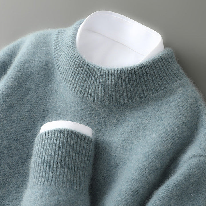 Texture shot of the knit pattern on a grey cashmere sweater, showing the fine fibers and luxurious feel.