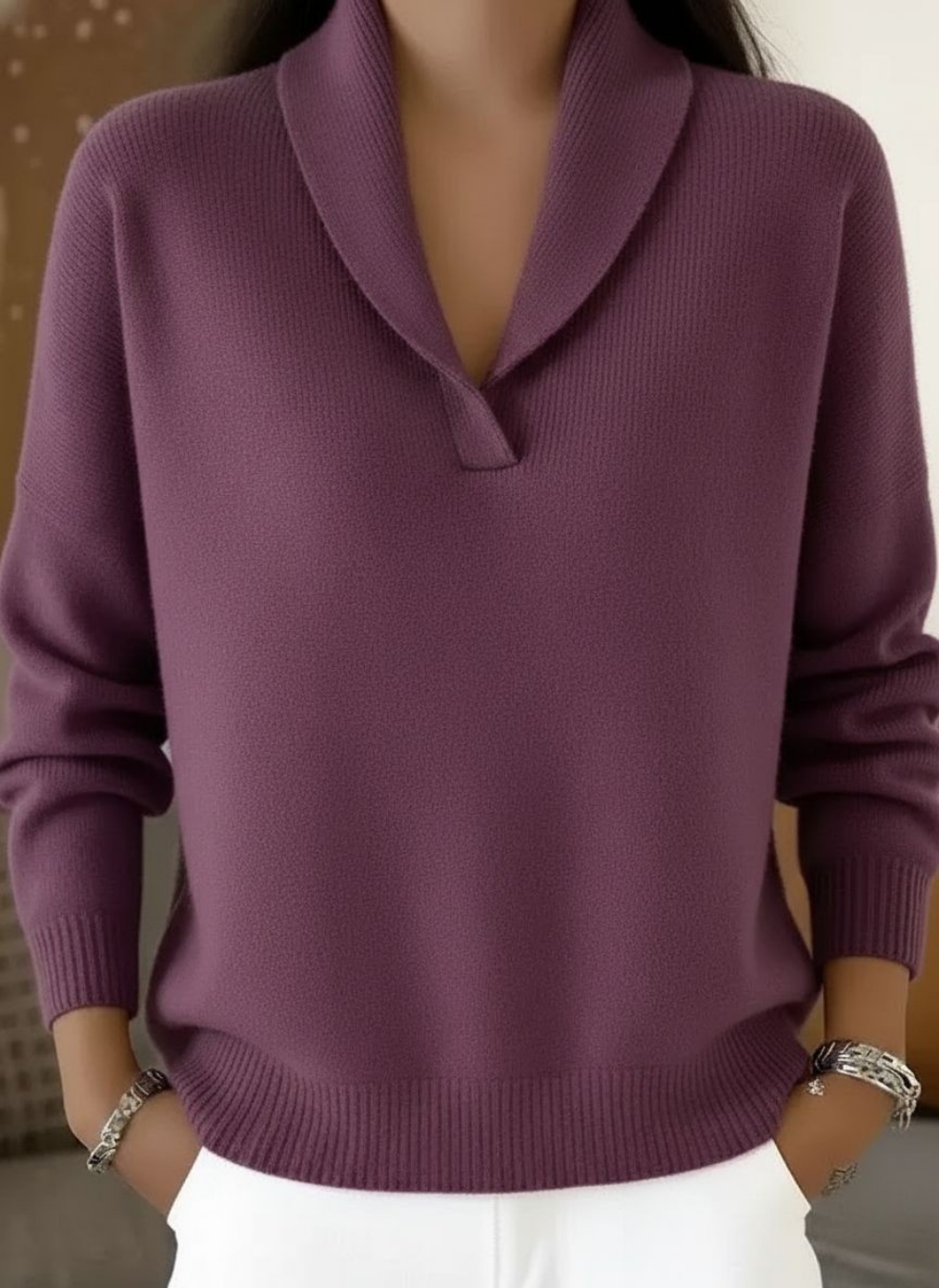 Detail shot of the V-neckline and shoulder seam on a white Seraphina V-neck sweater, showing craftsmanship.