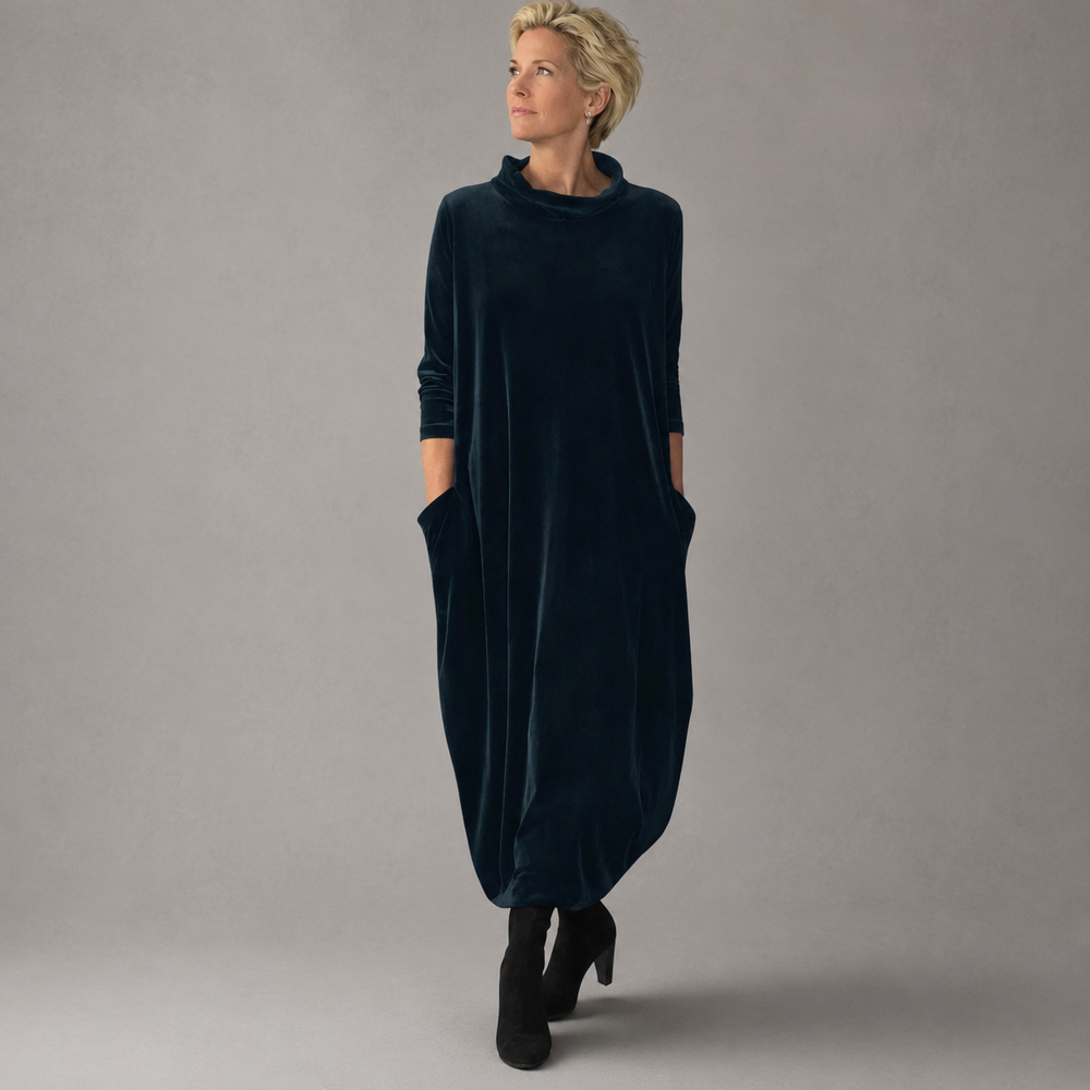 Side profile of the velvet maxi dress in blue, highlighting the flowing fabric and maxi length.