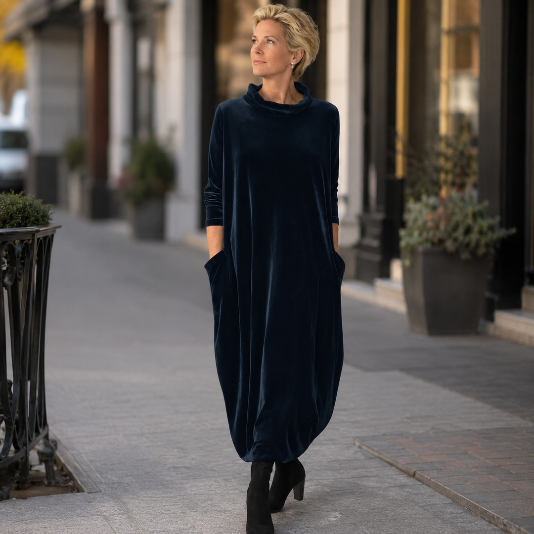 Back view of the purple velvet maxi dress, emphasizing the graceful drape of the fabric.