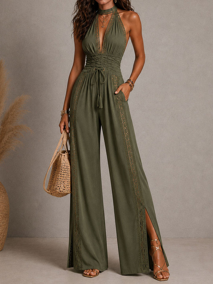 A woman posing in the black halter jumpsuit, emphasizing its elongated silhouette.