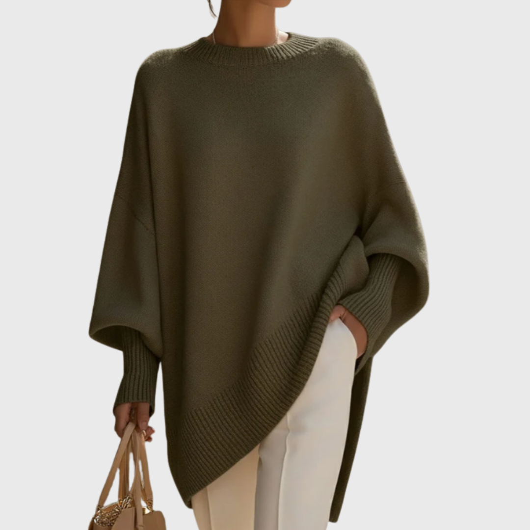Detail of the hemline and side slit of the Solana oversize poncho pullover, illustrating its elegant movement.