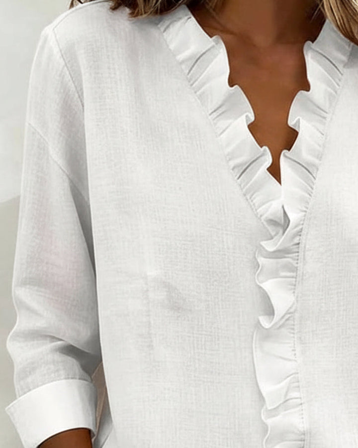 Fabric swatch detail of the cotton-linen blend of the ruffle V-neck blouse, showing material quality.