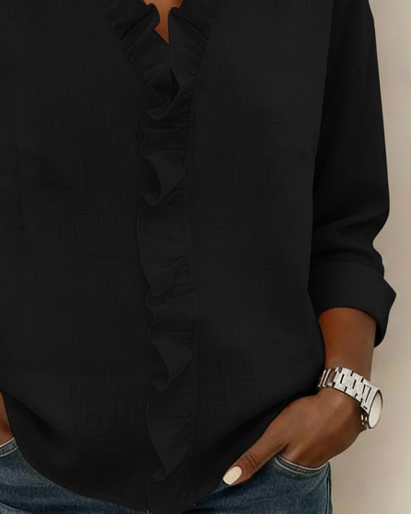 Overhead shot of a white ruffle V-neck long-sleeve blouse laid flat, showcasing its full design.