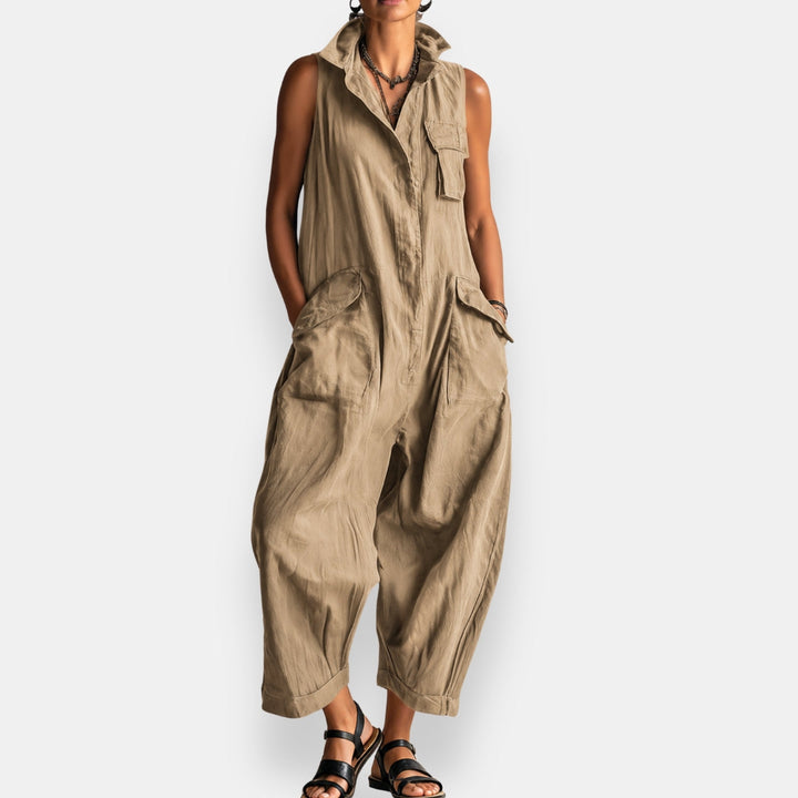 Side profile of a woman in a khaki relaxed sleeveless jumpsuit, highlighting the spacious side pockets.