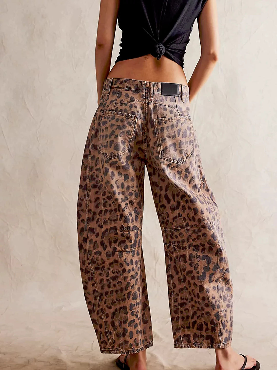 Detail of the four-pocket styling on the front of the fashionable leopard print jeans.