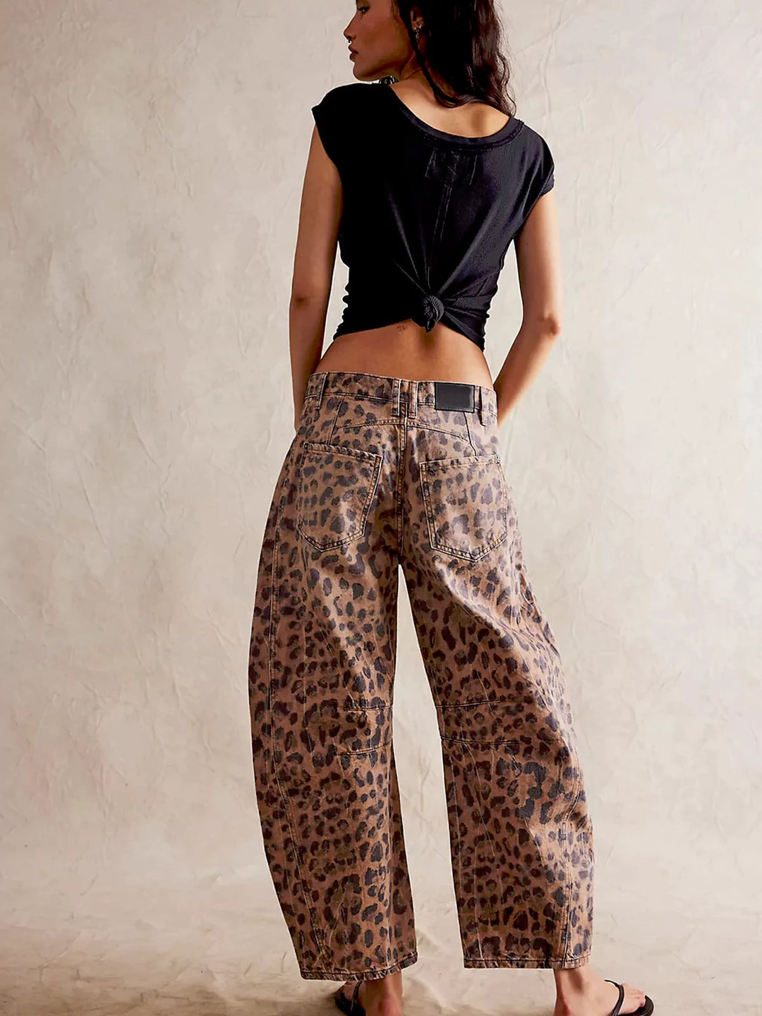 Angled shot of the wide-leg opening, emphasizing the relaxed fit of the leopard print denim.